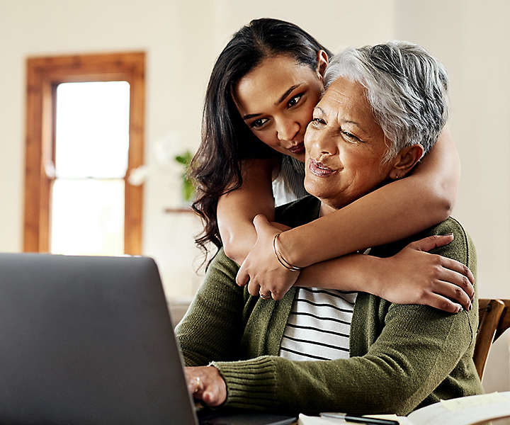 Daughter hugging grandmother at table