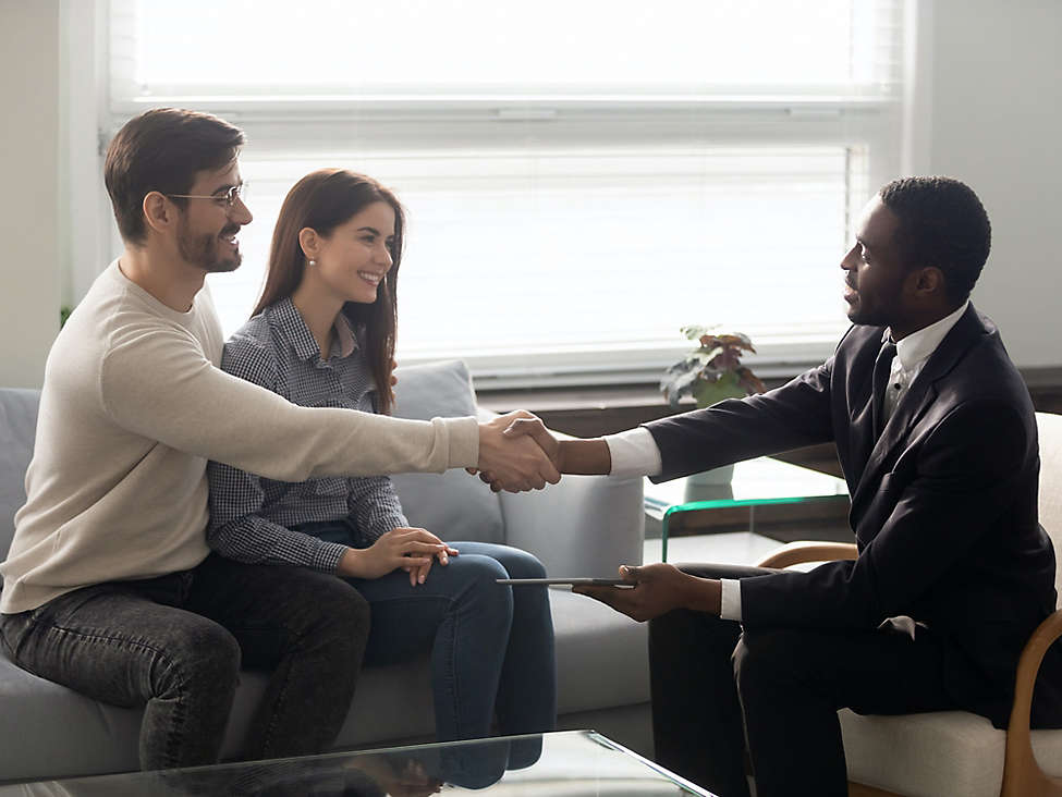Couple shaking hands with agent