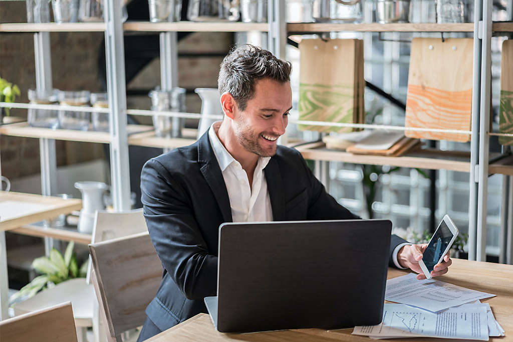 Man in office with phone and laptop