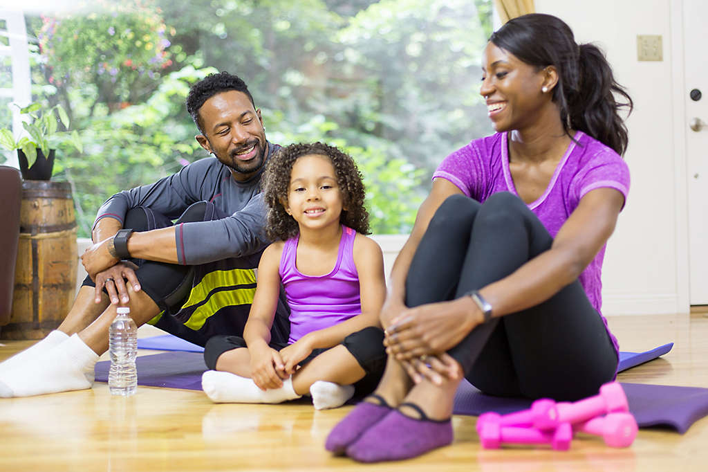 Family sitting together on exercise mats after a workout.