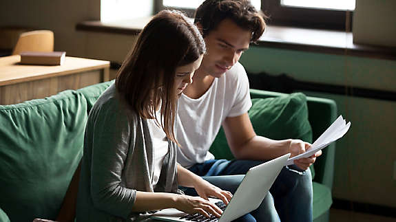 A younger couple reviewing finances while seated