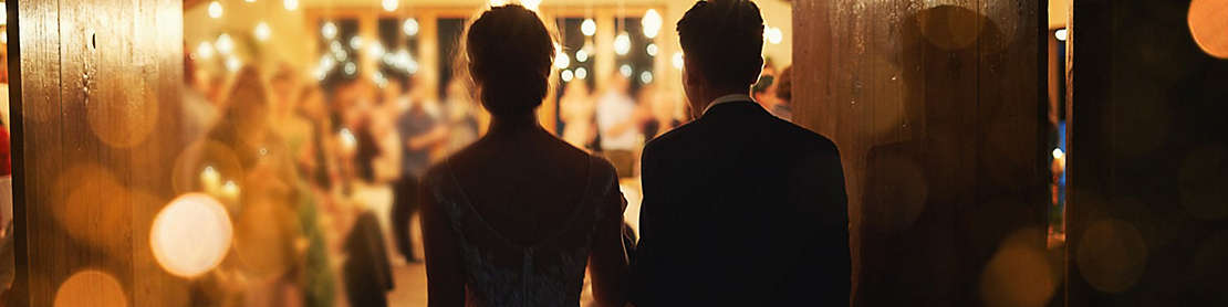 Newly married couple entering a reception hall.