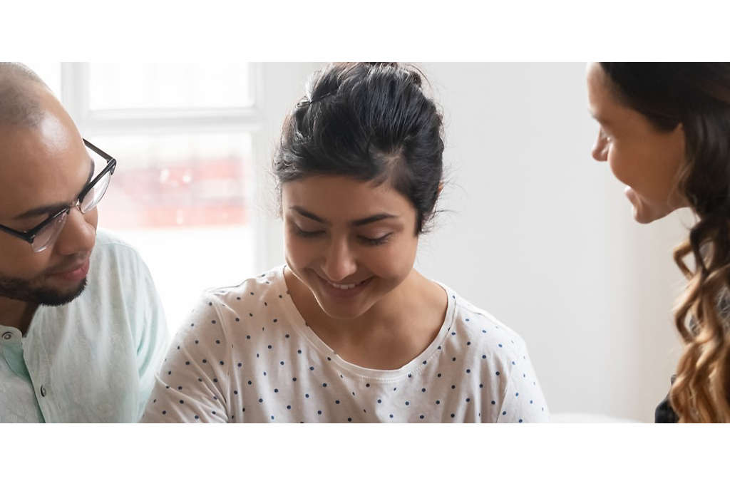 A couple sitting at a table reviewing paperwork with an agent.