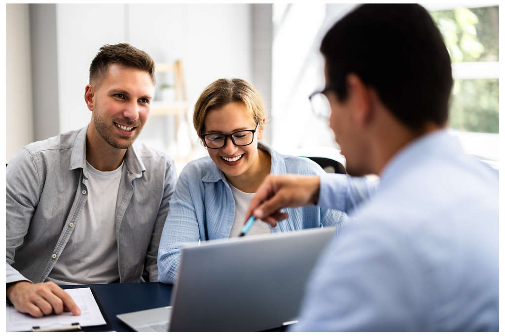 An advisor helping clients view their finances on a laptop