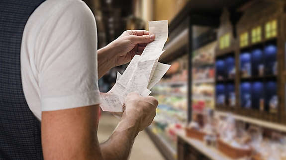 A person reviewing their store receipt