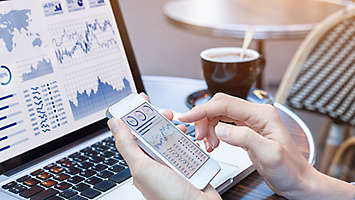 Charts and graphs on a laptop and phone screen