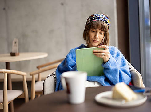 A woman using a tablet in a coffee shop