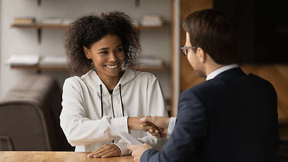 A woman shaking hands with a colleauge