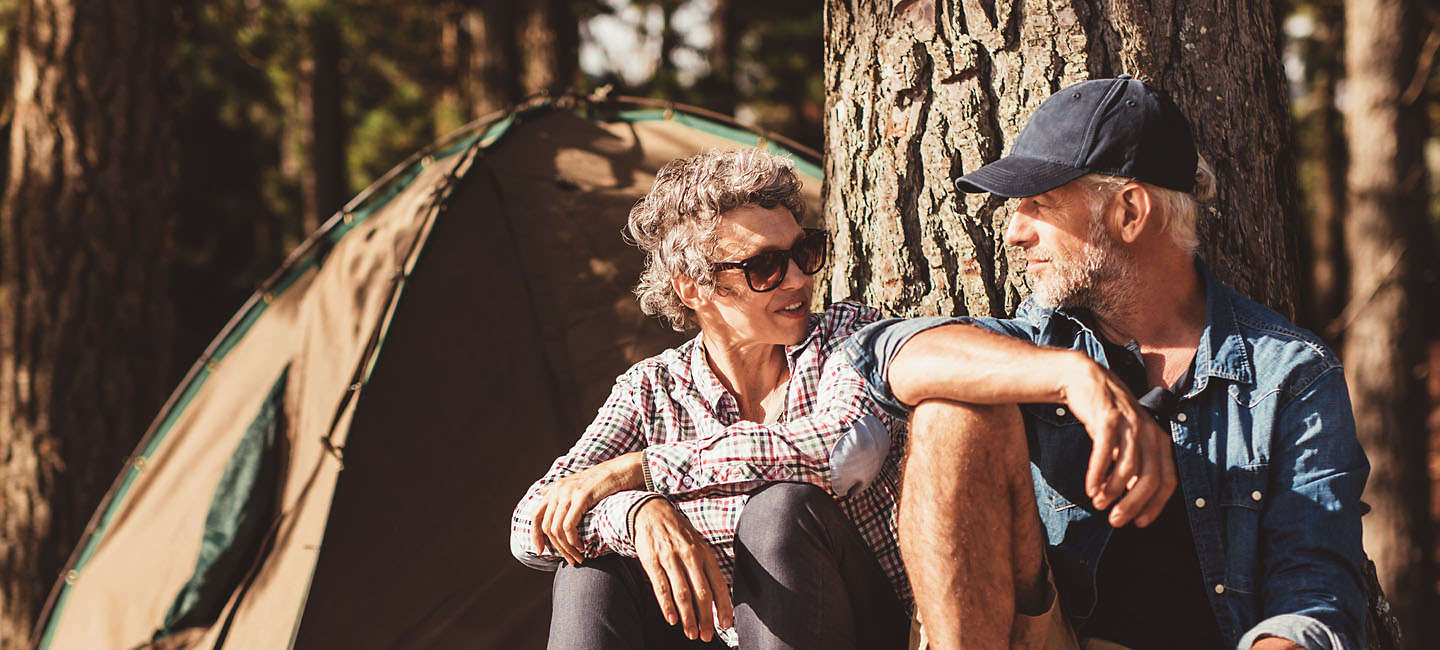 Older couple camping in the woods.