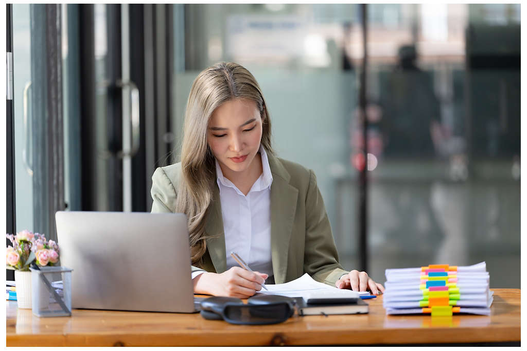 Businesswoman working at the workplace. beautiful Asian woman in a casual suit working reading a book, preparing for a meeting or interview in the office.