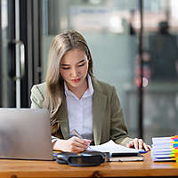 Businesswoman working at the workplace. beautiful Asian woman in a casual suit working reading a book, preparing for a meeting or interview in the office.