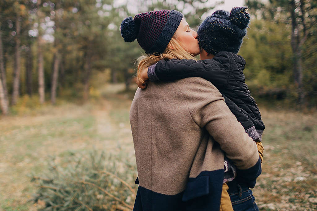 Mother holding and kissing her child