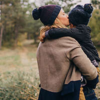 Mother holding and kissing her child