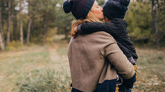 Mother holding and kissing her child