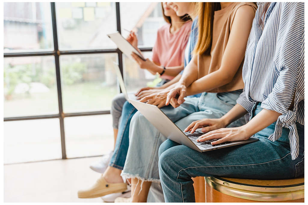 People sitting down in chairs looking at their laptops and tablets