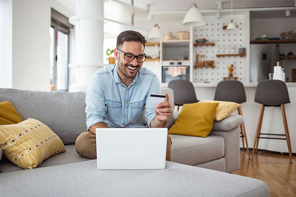 A man using his credit card to buy things on his laptop