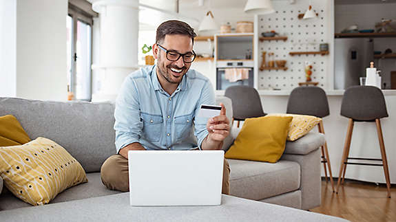 A man using his credit card to buy things on his laptop