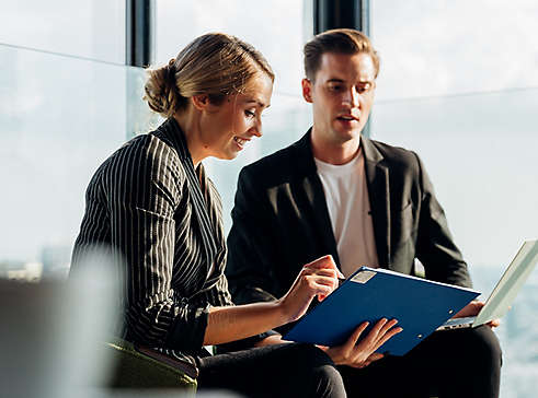 Man and woman looking at a clipboard.