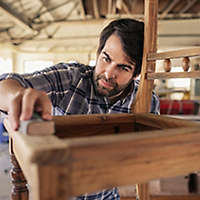 Man making a chair in a wood shop.