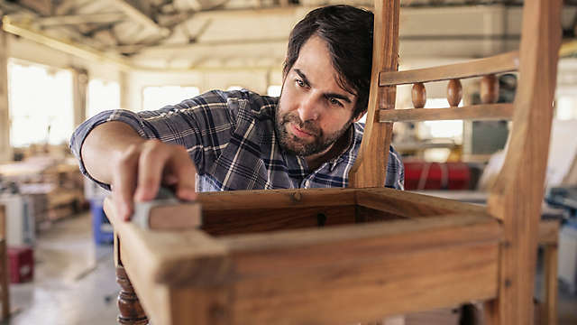 Man making a chair in a wood shop.