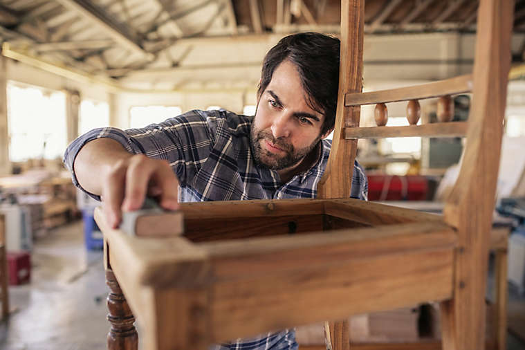 Man making a chair in a wood shop.