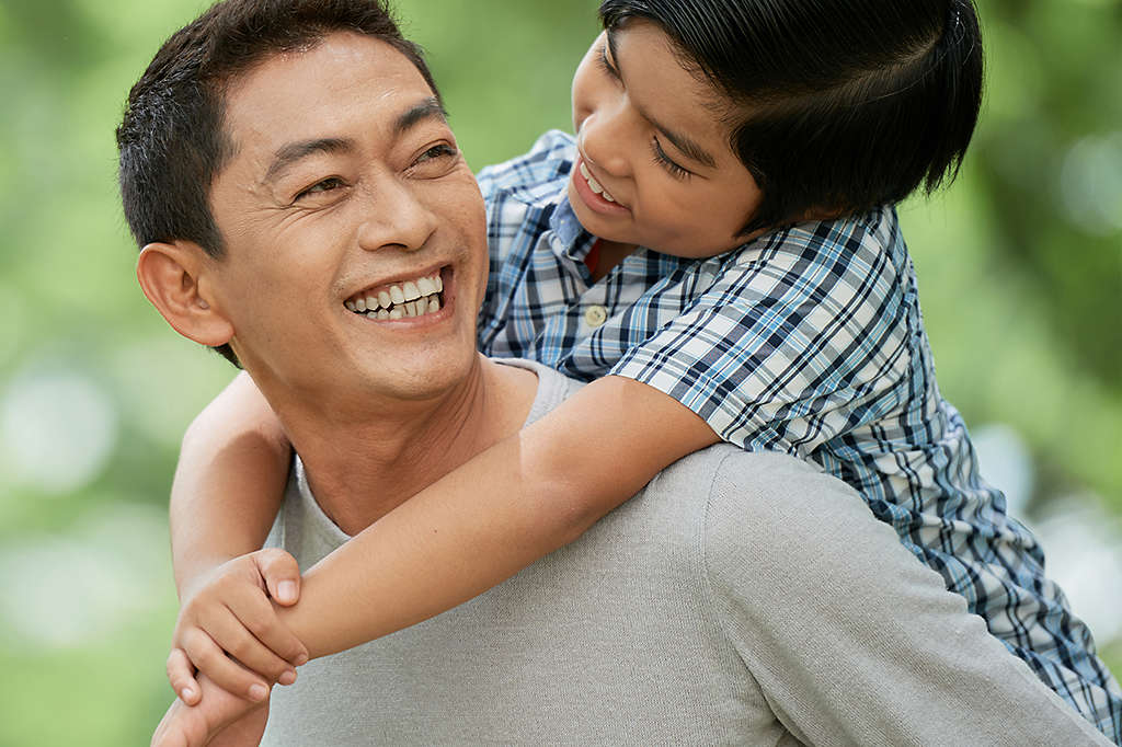 Father carrying son on back