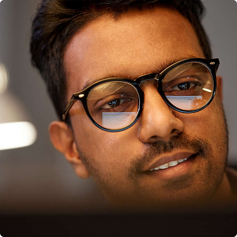 Man staring at computer screen with glasses on