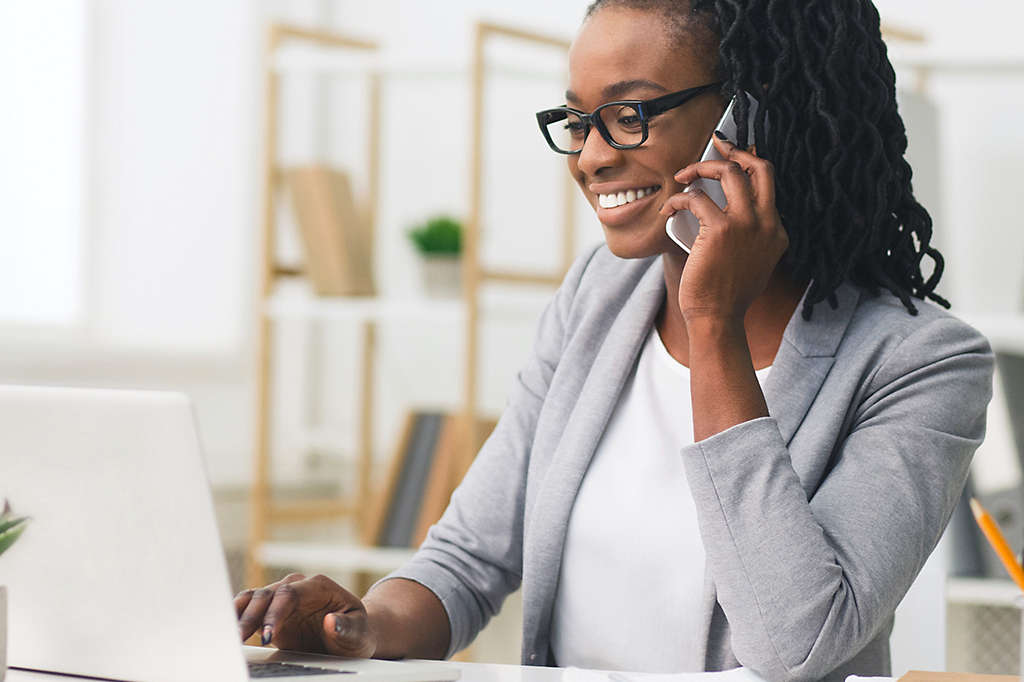 Person talking on phone while working on computer