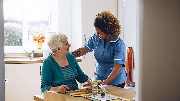 Nursing serving women breakfast