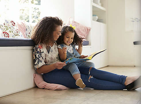 Person reading a book to a child