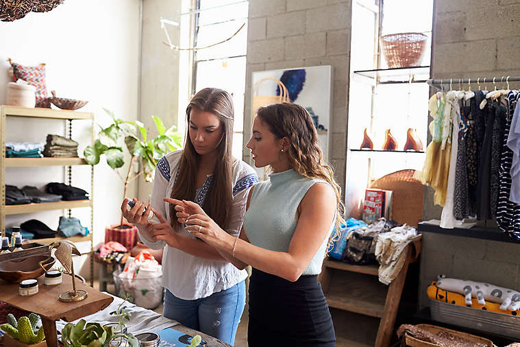 Two women looking at object in a store