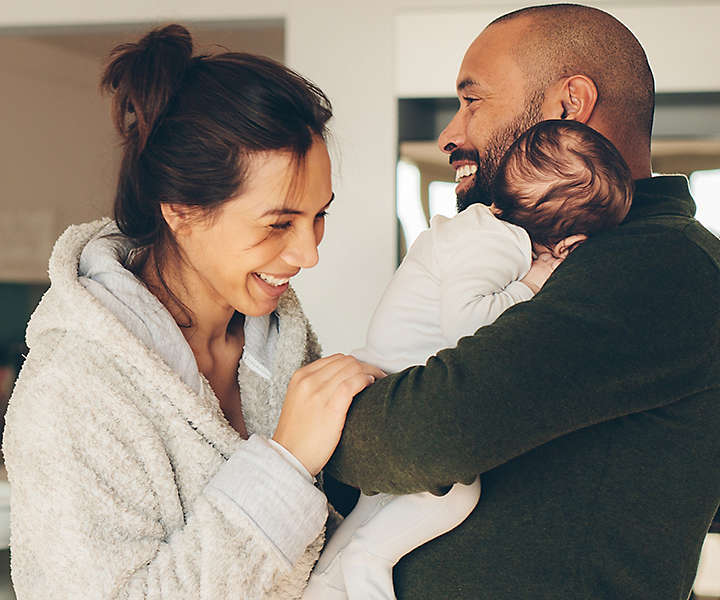 Couple hugging newborn