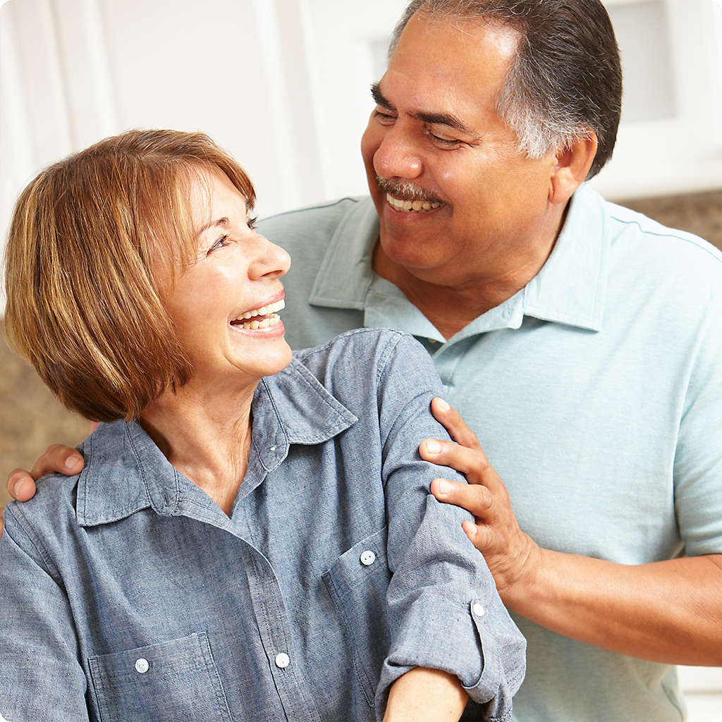 Husband and wife smiling at each other.