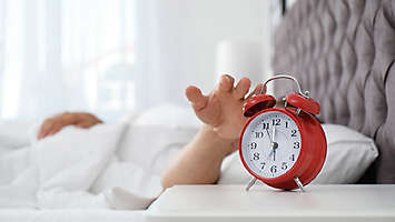  A person going to hit their alarm clock