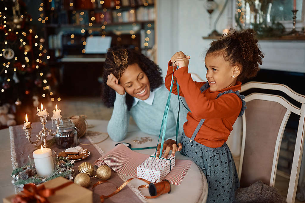 A woman with her daughter wrapping gifts