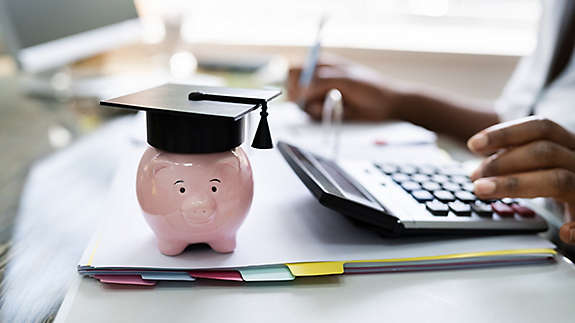 Piggy bank with a graduation cap on