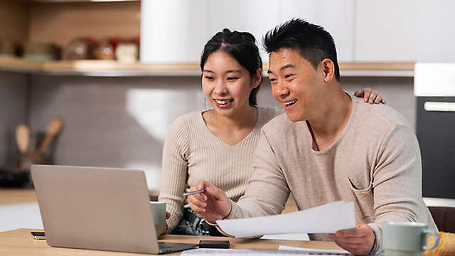 A man and a woman reviewing their finances on a computer