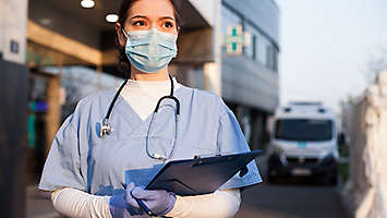 Nurse wearing a mark and holding a clipboard
