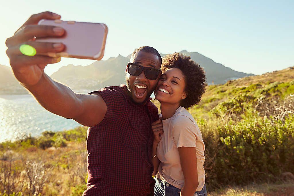 A man and woman taking a photograph in nature