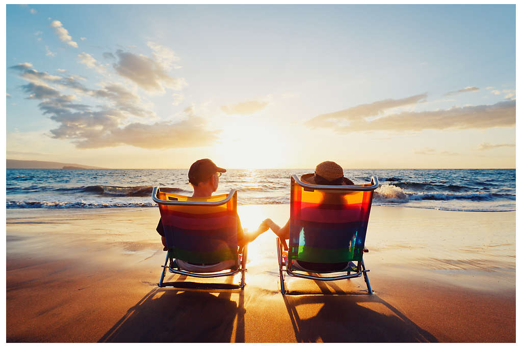 A couple sitting in beach chairs on the beach looking out towards the ocean