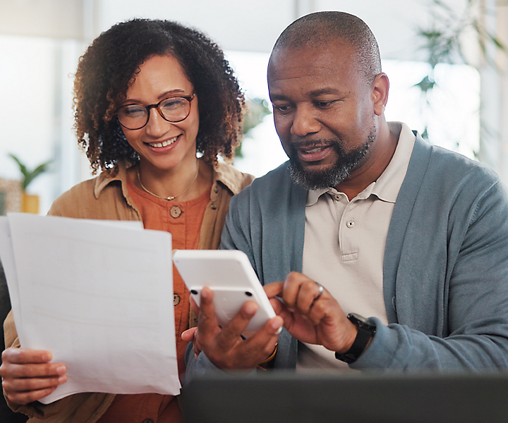 A couple using a calculator for their finances.