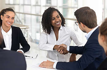 Employees in a meeting shaking hands