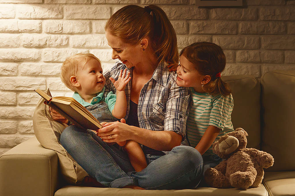 Mother reading a bedtime story to her two children
