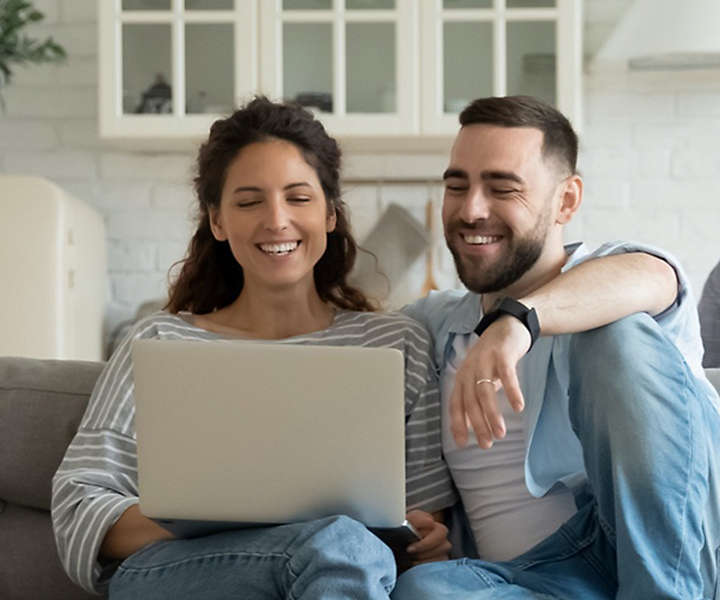couple-on-couch-with-a-laptop
