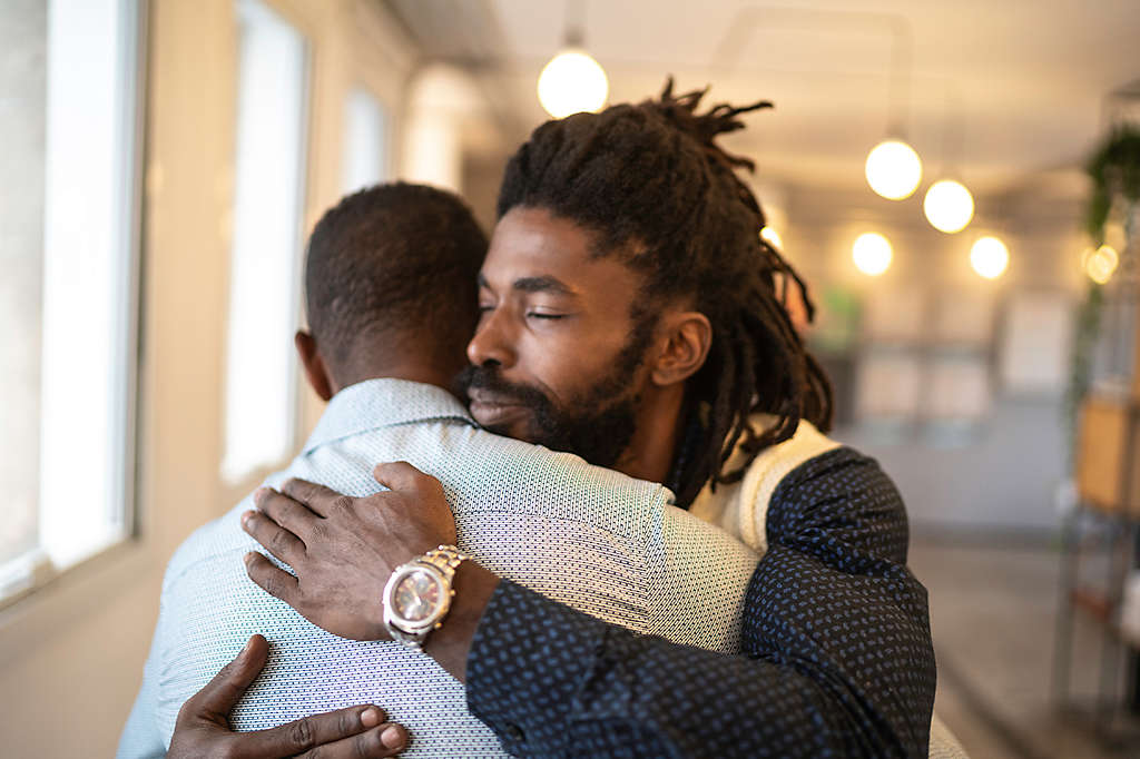 A not-too-sad photo of an employee comforting one of their peers, embodying a “culture of care”