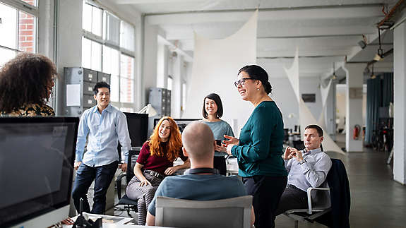 Employees in a break room gathered around a benefit update.