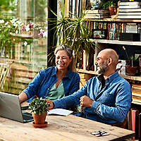 happy retired couple reviewing something on their laptop computer at home