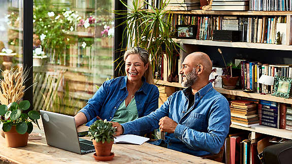happy retired couple reviewing something on their laptop computer at home