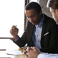 A young man looking over a document with an agent.