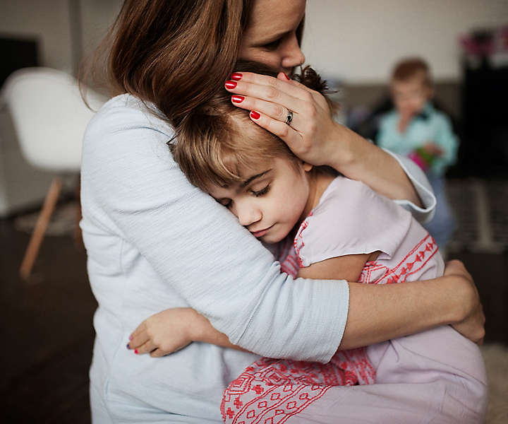 Mother hugging and caring grieving daughter at home